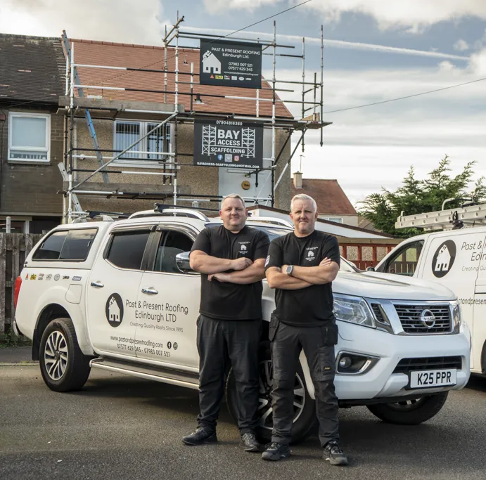 Derek and Keith of Past & Present Roofing in front of their branded vans